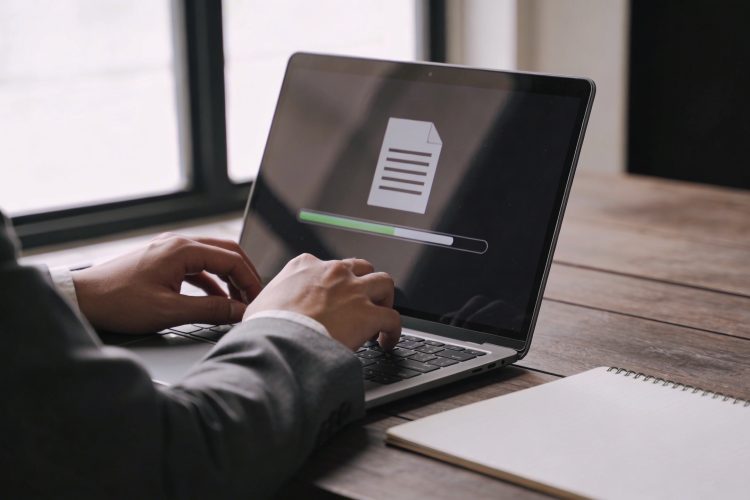 Employe assis envoyant un gros fichier numerique