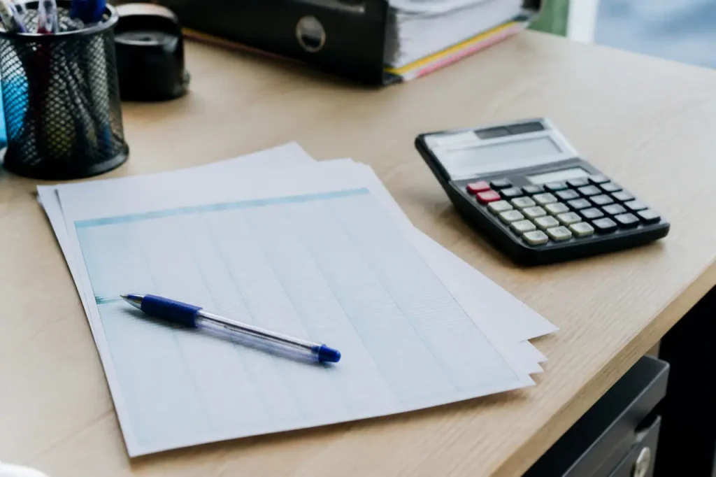 Bulletin de paie, stylo et calculatrice sur un bureau