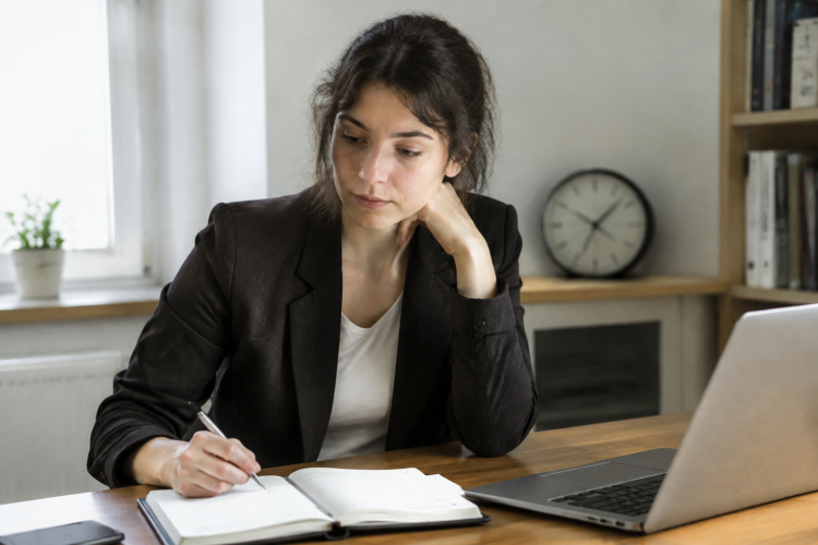 Employe assis devant un bureau avec agenda et horloge