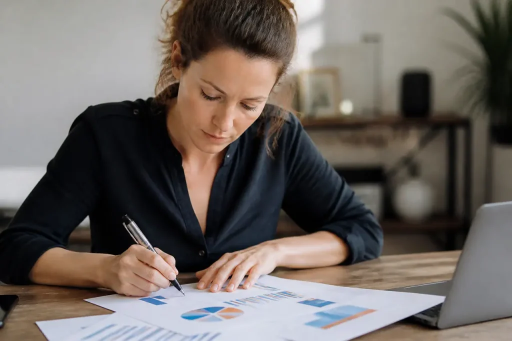 Une femme annote des graphiques imprimes avec un stylo