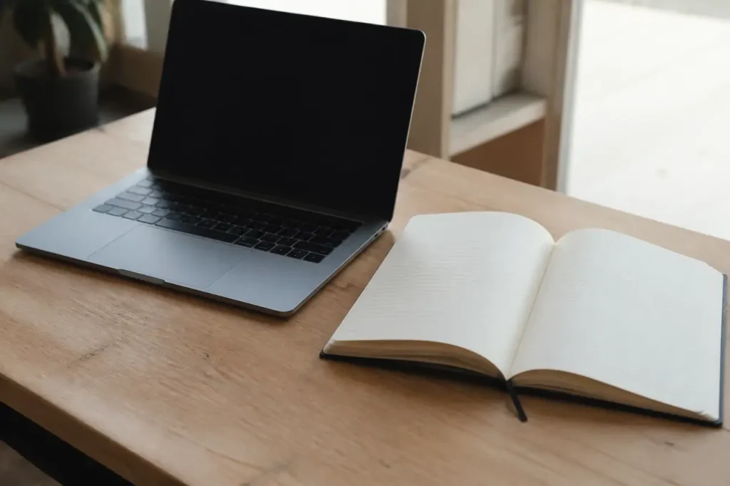 Ordinateur portable et carnet ouvert sur un bureau